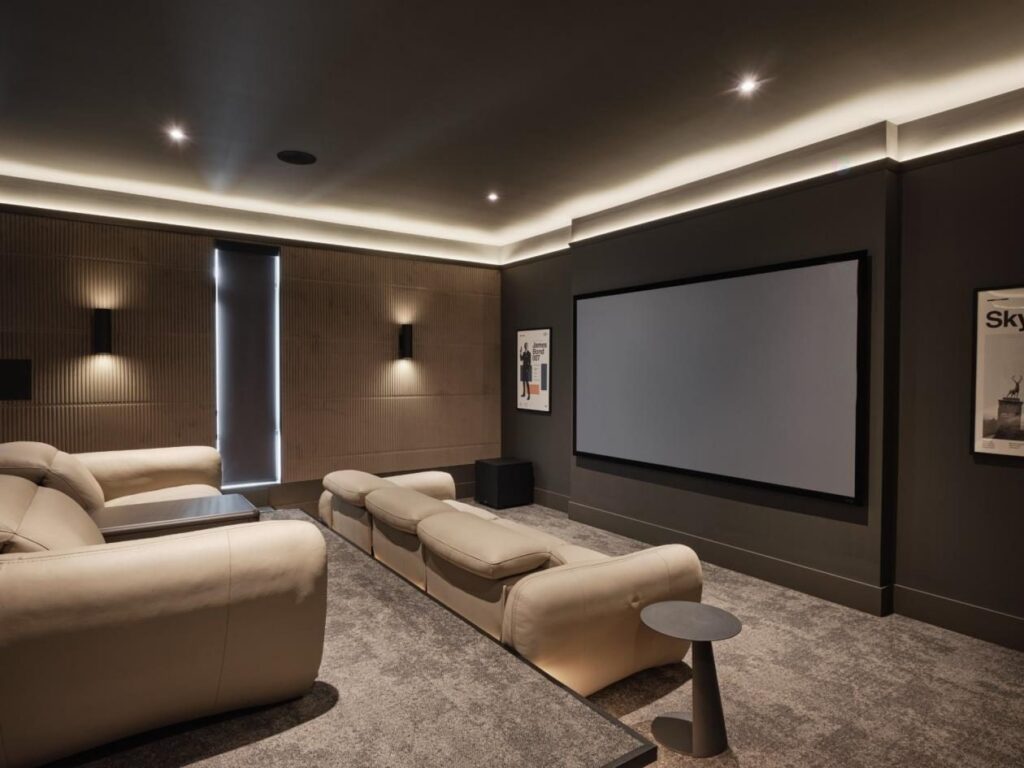 Cinéma maison dans une salle dédiée à l'acoustique traitée, éclairage d'ambiance encastré